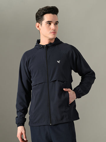 Man wearing a navy blue jacket with a brand logo on a gray background

